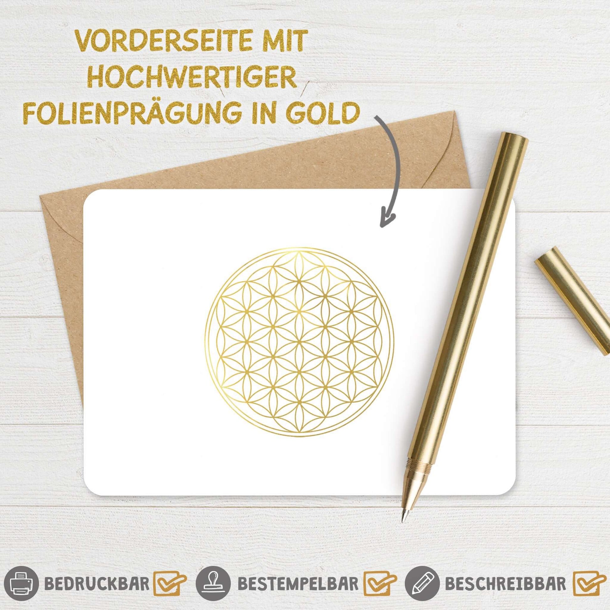 Karte "Blume des Lebens" mit goldfolierter Prägung, umgeben von einem Briefumschlag und einem goldenen Stift.