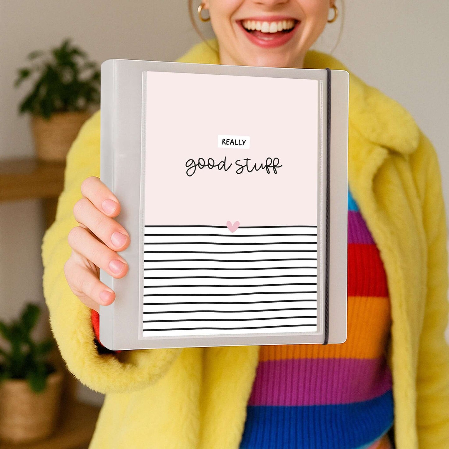Frau hält den DIN A5 Ordner „Good Stuff“ lachend in der Hand